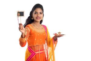 Beautiful Indian girl showing Rakhi on occasion of Raksha Bandhan with pooja thali and black board. Sister tie Rakhi as a symbol of intense love for her brother. photo