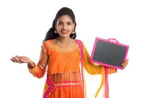 Beautiful young woman holding and posing with a blank chalkboard slate on a white background photo