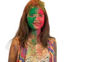 Portrait of a happy young girl with a colorful face on Holi color festival on white background photo