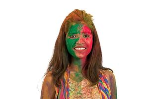 Portrait of a happy young girl with a colorful face on Holi color festival on white background photo