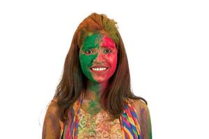 Portrait of a happy young girl with a colorful face on Holi color festival on white background photo