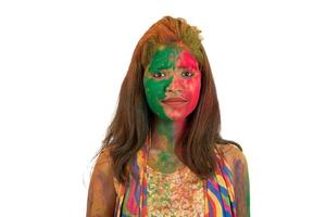 Portrait of a happy young girl with a colorful face on Holi color festival on white background photo