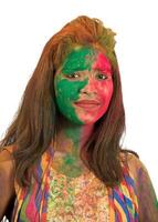 Portrait of a happy young girl with a colorful face on Holi color festival on white background photo