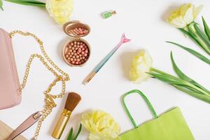 Decorative flat lay composition with cosmetics and flowers. Flat lay, top view on white background photo