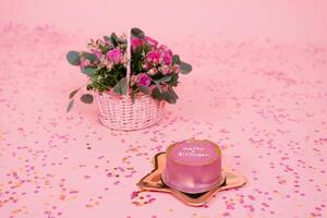 Stylish pink and gold festive Korean bento cake on a golden plate in the shape of a star on a pink background with confetti and a basket with fuchsia roses photo