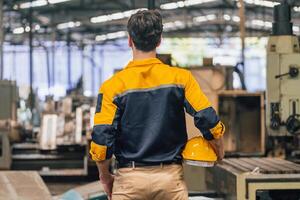 Caucasian engineer using a laptop in a factory. man working in plastics factory. photo