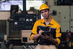 Caucasian engineer using a laptop in a factory. man working in plastics factory. photo