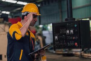 Caucasian engineer using a laptop in a factory. man working in plastics factory. photo