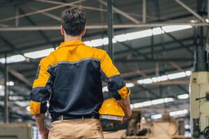 Caucasian engineer using a laptop in a factory. man working in plastics factory. photo
