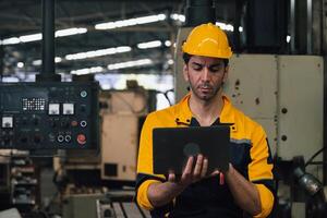 Caucasian engineer using a laptop in a factory. man working in plastics factory. photo