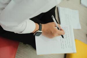 Modern Student Taking Notes Smartwatch and Pen in Hand photo
