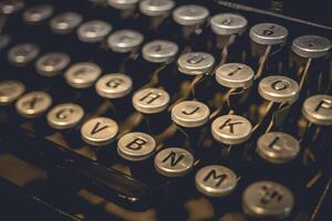 A close-up of the keys on an old typewriter, showing the letters G, H, J, K, L, V, B, N, M, and O photo