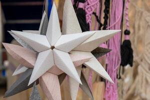A close-up of a wooden star ornament hanging in a craft market photo