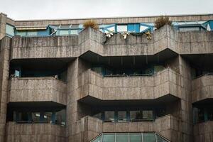 A concrete apartment building with balconies and windows in an urban setting photo