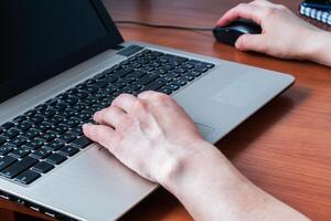 Working wooden table at home or in the office. Woman working at computer hands photo