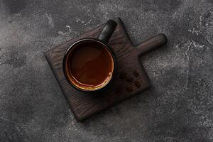 Black coffee in a Cup and coffee beans on a dark background. Top view Copy space. photo