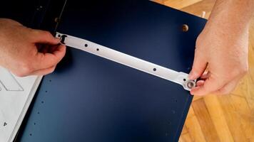 Hands assembling furniture at home, emphasizing DIY and home improvement concepts photo