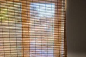 Sunlight filtering through bamboo blinds in a cozy room, representing tranquility and home comfort photo