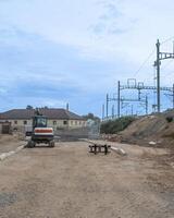 Construction site near railway tracks with empty benches, symbolizing incomplete infrastructure development and urban planning issues photo