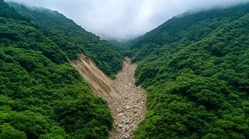 Massive landslide crushing a mountainside rocks and debris sliding down violently through dense green forest photo