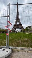 The Eiffel Tower viewed through a construction fence highlights urban development challenges and tourism in Paris photo