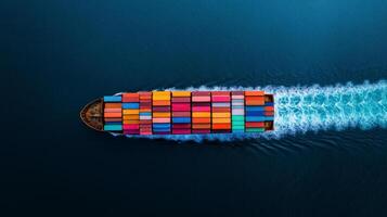 Aerial view of a container ship cutting through the open ocean multi colored cargo containers arranged in perfect rows on its deck smooth sea below photo