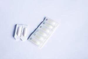 Pills and the medical candles on soft light background photo