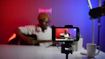 African american blogger plays the guitar live and recording for blog video