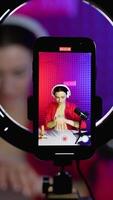 Woman blogger vlogger is showing cream while recording blog. Vertical video