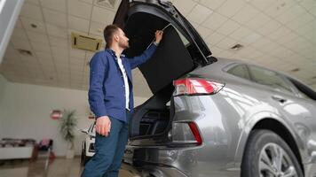 Customer choosing new car and checks it before purchasing in car dealership video