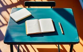 Flat lay green desk view with open notepad, pen and long shadows. Back to school or educational concept. photo