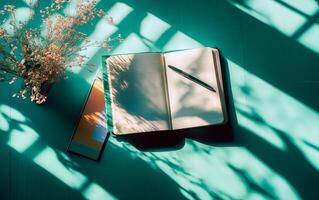 Flat lay green desk view with open notepad, pen and long shadows. Back to school or educational concept. photo