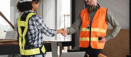 Engineering Team Plans Construction Work with Handshake in Modern Office, Collaboration and Teamwork in Construction Industry, Engineers in Safety Vests and Helmets, Planning and Coordination photo