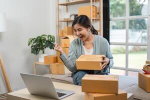 Young Woman Packing Boxes of Merchandise for Online Sales in a Modern Home Office Setting photo