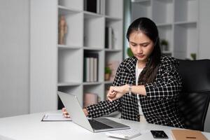 Office Worker Checking Time While Working Late in Modern Office Environment photo