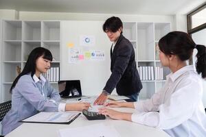 Young Business Team Collaborating on Marketing Strategy in Modern Office Setting with Charts and Graphs photo