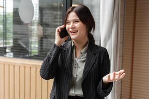 Confident Business Woman in Modern Office Environment Using Smartphone for Communication and Networking photo