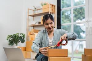Young Woman Packing Boxes of Merchandise for Online Sales in a Modern Home Office Setting photo