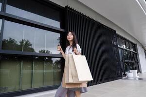 Stylish Woman Enjoying a Shopping Spree at the Mall with Paper Bags in Hand on a Sunny Day photo
