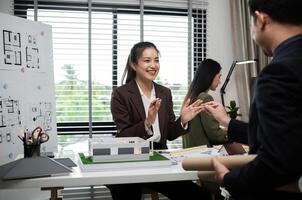 Business Team Discussing Real Estate Project with Architectural Plans and Model in Modern Office Setting photo