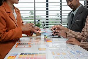 Creative Team Collaborating on UX UI Design Concepts with Color Swatches and Wireframes in Modern Office Setting photo