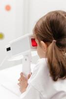 A young girl engages in orthoptic and pleoptic therapy using advanced vision stimulation equipment. Laser eye treatment promotes recovery and enhances vision in a soothing environment photo