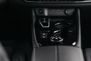 Modern car center console with electronic gear selector, stylish design, and control buttons. Ideal for automotive content, advertising, and blogs, highlighting comfort and technology photo