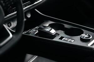 Modern car center console with electronic gear selector, stylish design, and control buttons. Ideal for automotive content, advertising, and blogs, highlighting comfort and technology photo