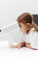 A young girl engages in orthoptic and pleoptic therapy using advanced vision stimulation equipment. Laser eye treatment promotes recovery and enhances vision in a soothing environment photo
