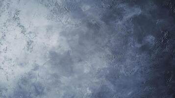 A grey wall with a few spots of white. The wall is covered in a greyish-blue paint photo