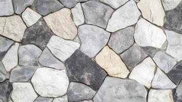 A stone wall with a variety of different colored stones. The wall is made up of many different sized stones. photo