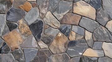 A wall made of stone and gray and brown stones. The wall is made of many different sized stones. photo