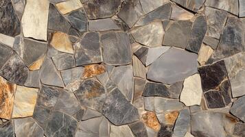 A wall made of stone and gray and brown stones. The wall is made of many different sized stones. photo
