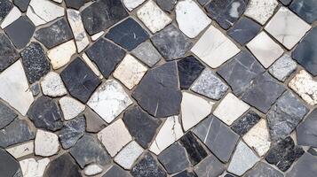 A black and white mosaic tile pattern. The tiles are of different sizes and shapes. photo